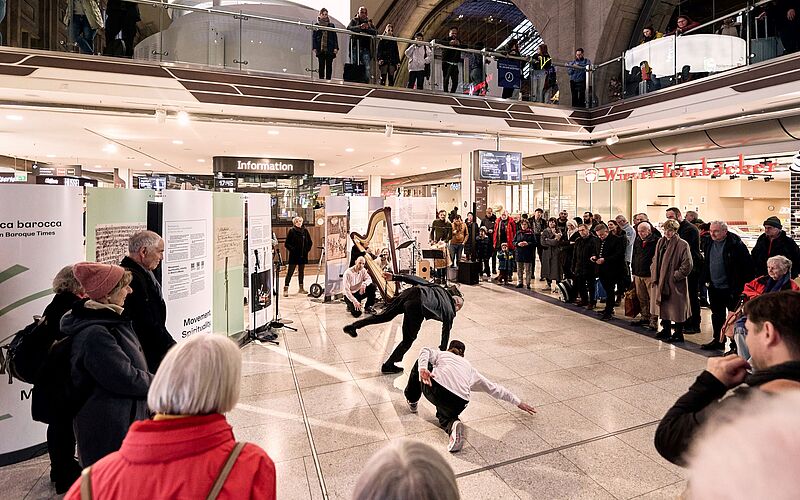In der Mitte des Bildes tanzt ein Breakdancer, drum herum steht Publikum.